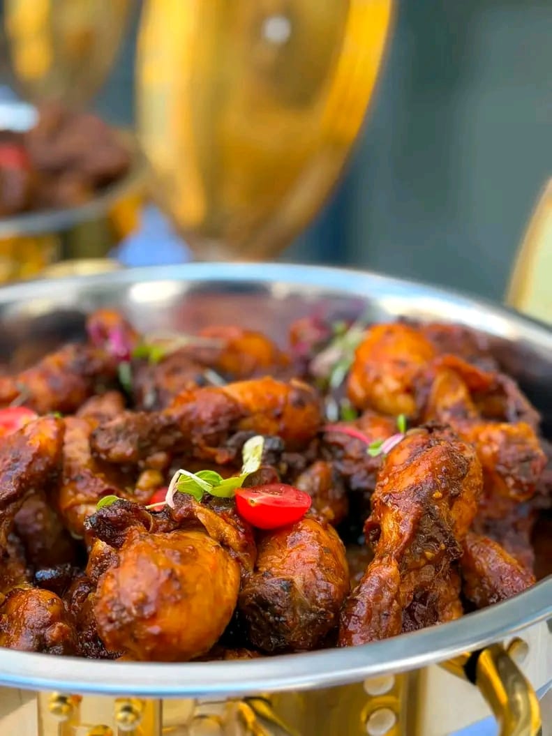 Braised chicken pieces served in a silver chafing dish