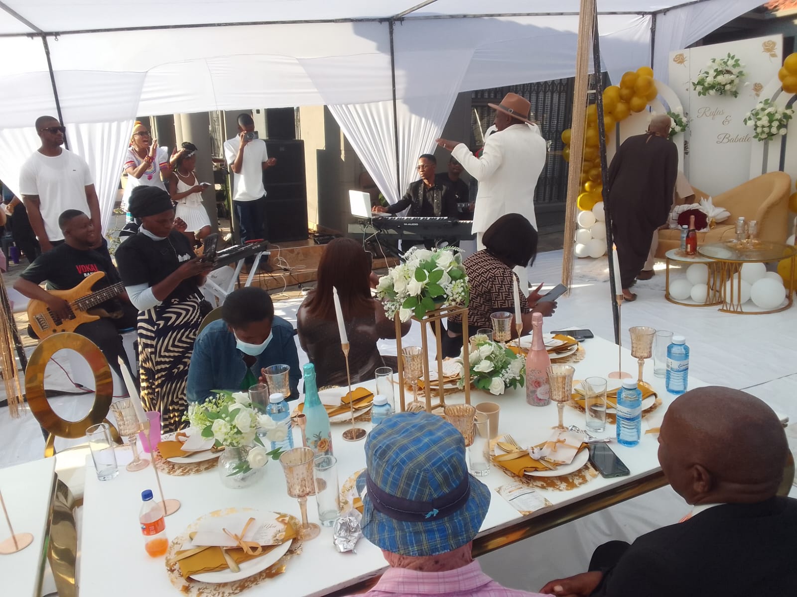 Guests seated at a gold and white decorated wedding table